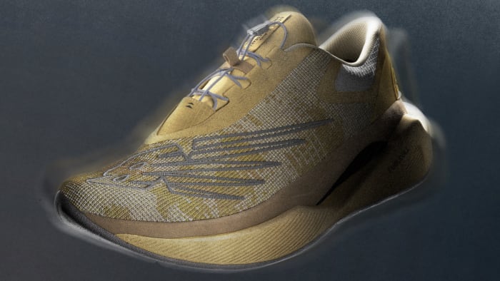 Side view of a tan and grey New Balance running shoe.